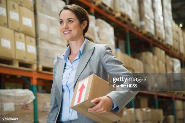 businesswoman in warehouse - vrachtruimte stockfoto's en -beelden