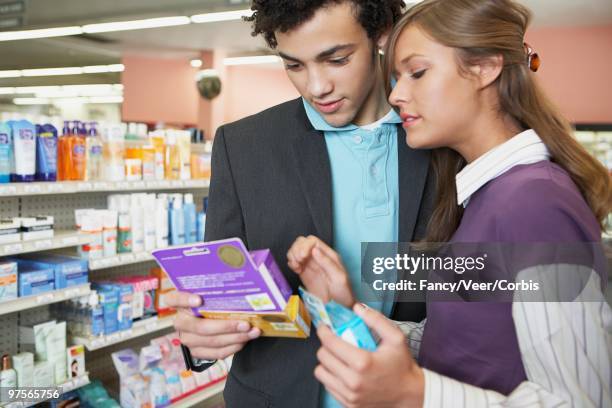 couple selecting contraception - condom stock pictures, royalty-free photos & images