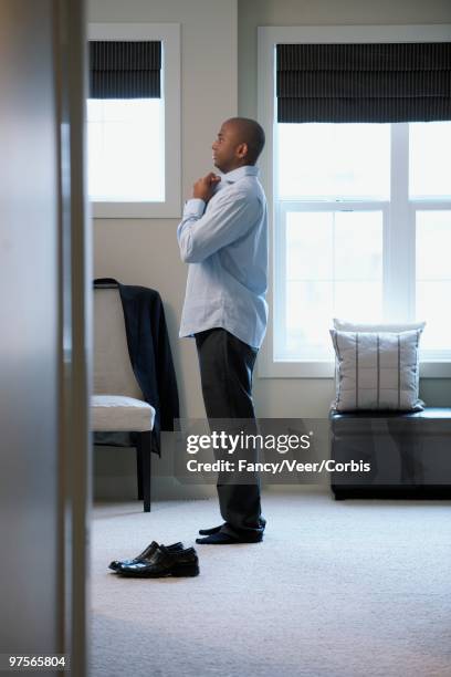 man dressing - adjusting necktie stockfoto's en -beelden