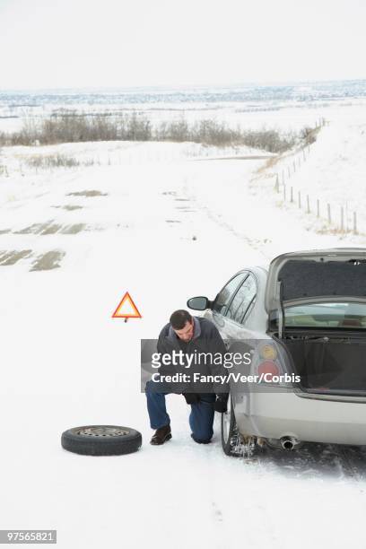 changing a tire in the snow - veer stock pictures, royalty-free photos & images
