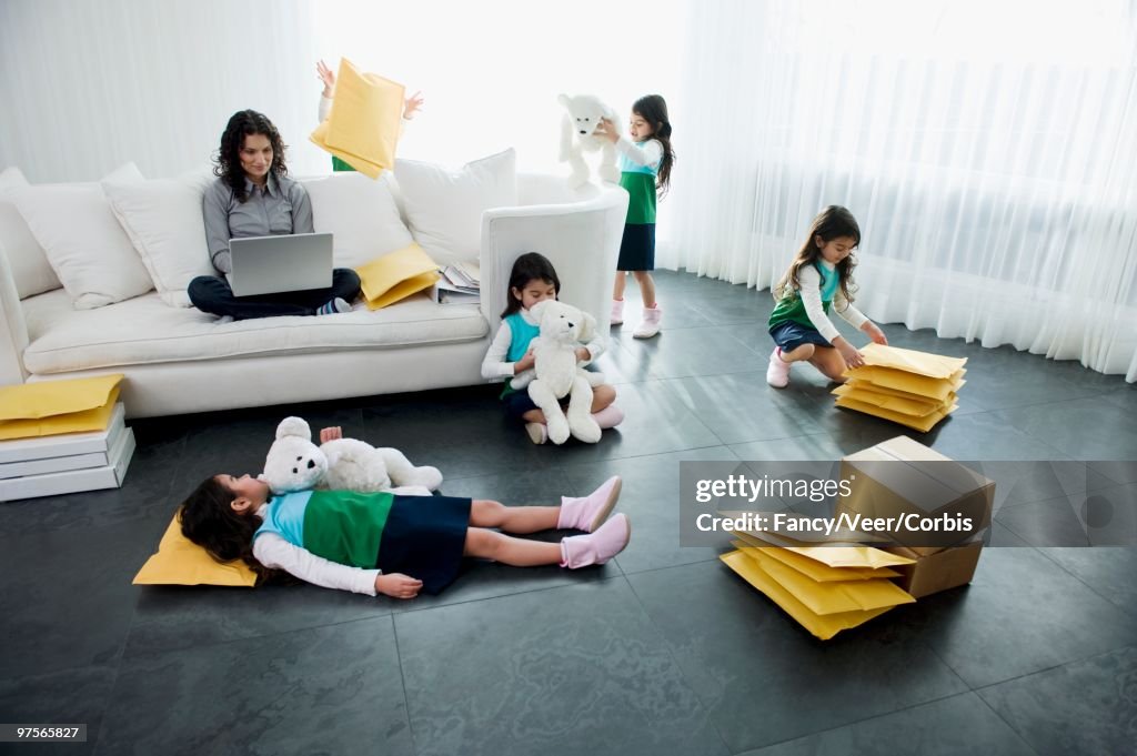 Girl Playing in Living Room While Mother Using Laptop Computer