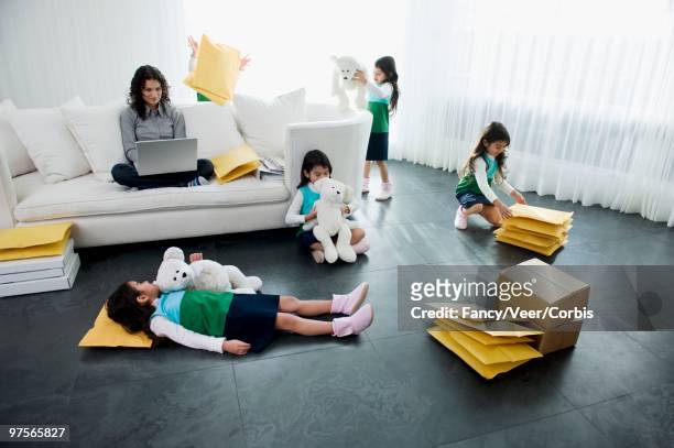 girl playing in living room while mother using laptop computer - multiple images of the same woman stock pictures, royalty-free photos & images