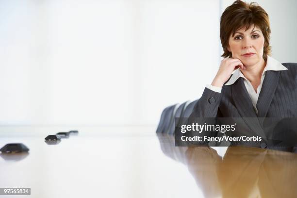 businesswoman sitting at conference table - veer stock pictures, royalty-free photos & images