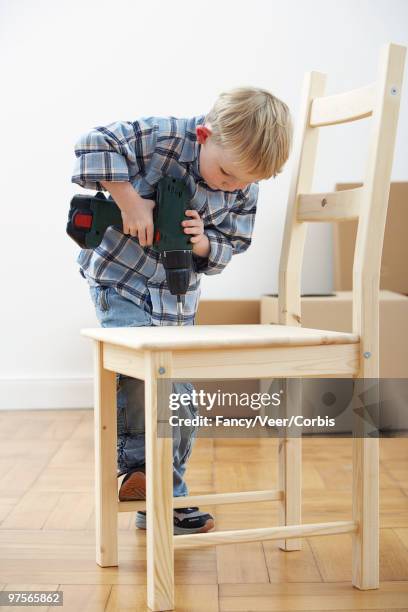 boy assembling a chair - veer stock pictures, royalty-free photos & images