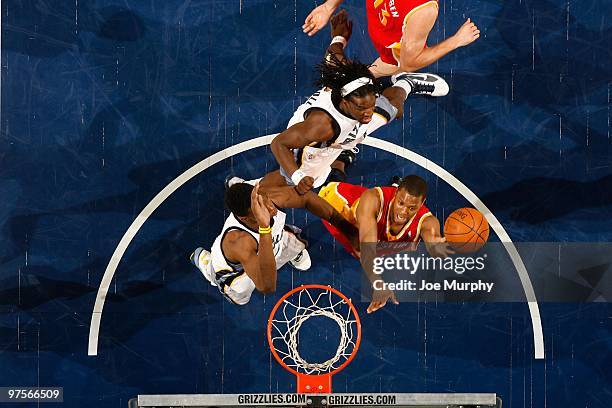 Kyle Lowry of the Houston Rockets lays up a shot against DeMarre Carroll and Hasheem Thabeet of the Memphis Grizzlies during the game on February 5,...