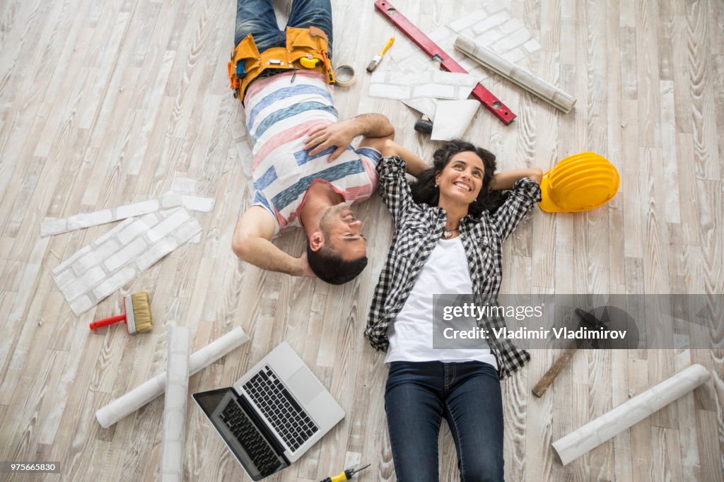 Couple renovating and resting on floor