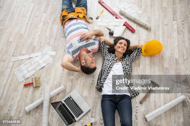 couple renovating and resting on floor - rebuilding stock pictures, royalty-free photos & images