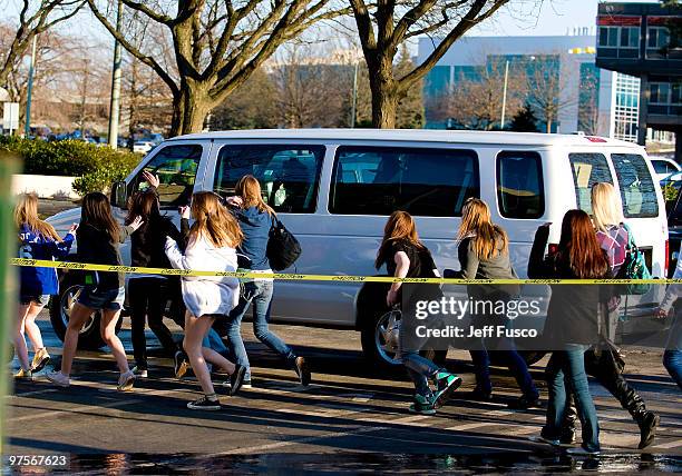 Fans chase a van with Patti Bieber inside at the Q102 radio station prior to an appearance by singer Justin Bieber on March 8, 2010 in Bala Cynwyd,...