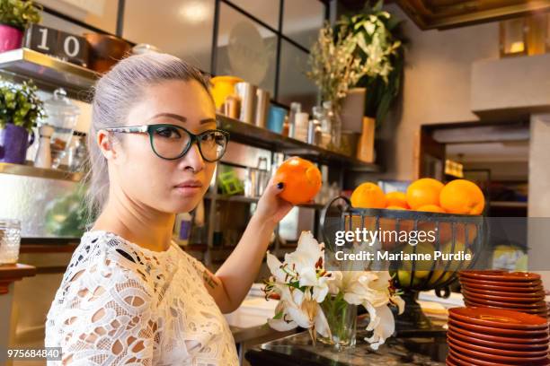 choosing an orange from a basket - ネーブルオレンジ ストックフォトと画像