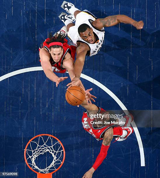 Devin Harris and Josh Boone of the New Jersey Nets battle for a rebound against Darrell Arthur of the Memphis Grizzlies on March 8, 2010 at...