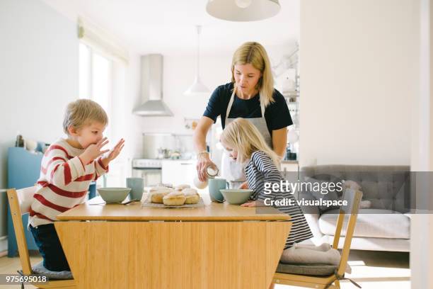 nordic family eating semla buns on shrove tuesday - mother son milk imagens e fotografias de stock
