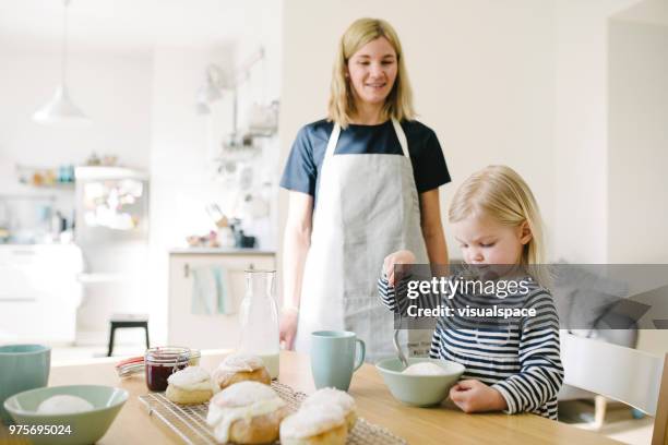 moeder en haar schattige dochter semla broodjes eten op vastenavond - sweet bun stockfoto's en -beelden