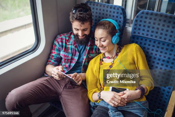 junges paar im zug surfen im netz auf dem tablet - voyage train stock-fotos und bilder