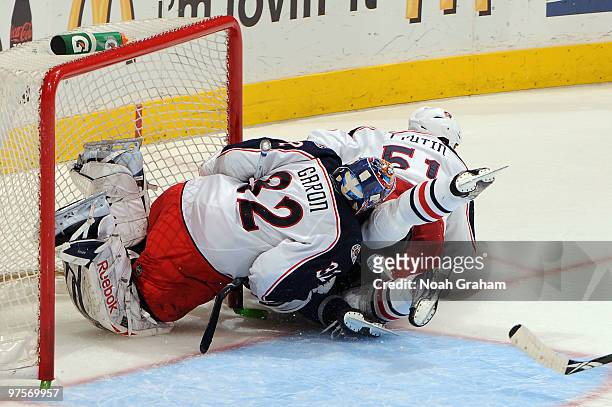 Dustin Brown of the Los Angeles Kings falls between Mathieu Garon and Fedor Tyutin of the Columbus Blue Jackets on March 8, 2010 at Staples Center in...