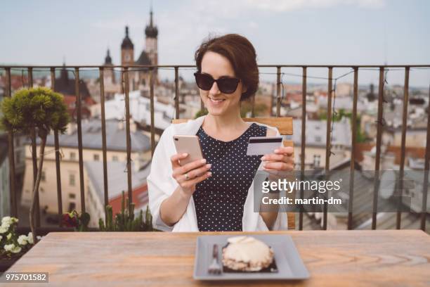 Smiling woman traveling in Europe and shopping online with credit card