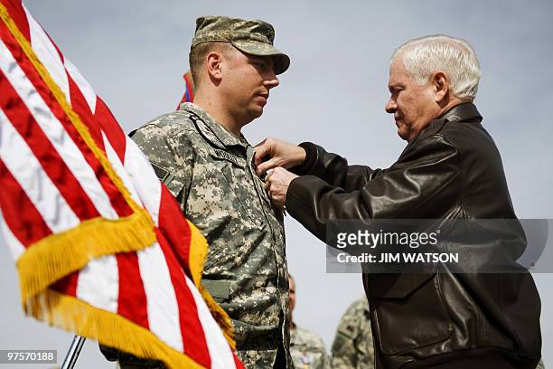 Secretary of Defense Robert Gates pins the Silver Star on US Army Chief Warrant Officer 3 James Woolley, of Task Force Tallon, during an award...