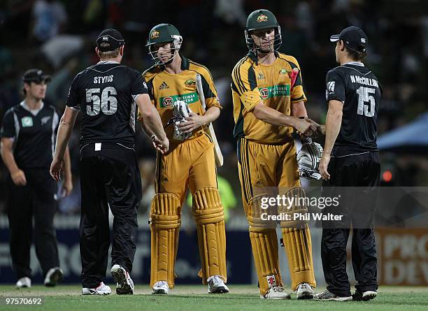 Cameron White and Adam Voges of Australia shake hands with the New Zealand fielders during the One Day International match between New Zealand and...