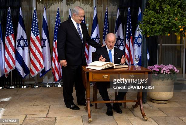Vice President Joe Biden gestures alongside Israeli Prime MInister Benjamin Nentanyahu as he signs a guestbook prior to their meeting at the Prime...