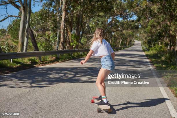 woman skating down highway on longboard - longboard skating 個照片及圖片檔