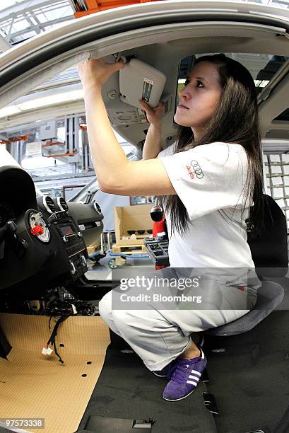 An Audi employee works on the interior of an Audi A3 automobile as it passes along the assembly line at the Audi AG factory in Ingolstadt, Germany,...