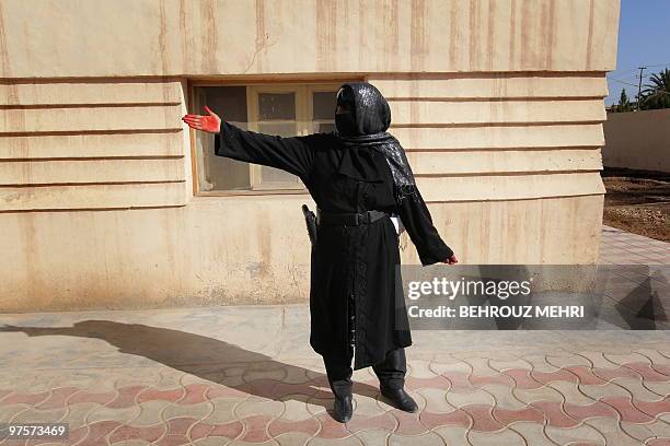 An Afghan policewoman indicates to unseen attendees where to proceed for a ceremony to mark International Women's Day in Lashkar Gah in Helmand...