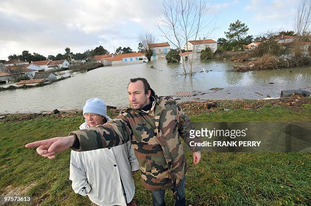 Two people watch damages caused by heavy floods overnight, in La Faute-sur-Mer, western France, on February 28, 2010. Dubbed "Xynthia", the Atlantic...