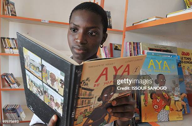 Evelyne AKA A girld reads Ivory Coast's Marguerite Abouet comic book "Aya de Yopougon" on October 26, 2009 in Abidjan. With more than 300.000 copies...