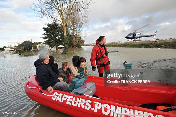 Residents are evacuated in a zodiac by firefighters, on February 28 as a result of heavy floods, in La Faute-sur-Mer western France. Dubbed...