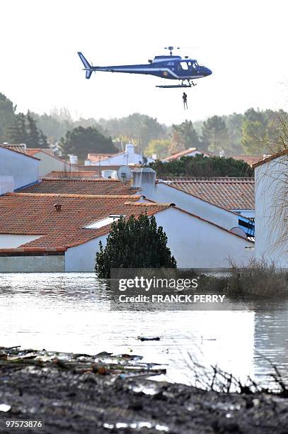 Person is airlifted by an helicopter of the National Gendarmerie, on February 28 as a result of heavy floods over a residential area, in La...