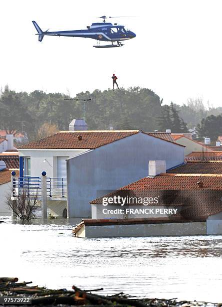 Person is airlifted by an helicopter of the National Gendarmerie, on February 28 as a result of heavy floods over a residential area, in La...
