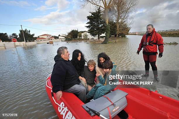 Residents are evacuated in a zodiac by firefighters, on February 28 as a result of heavy floods, in La Faute-sur-Mer western France. Dubbed...