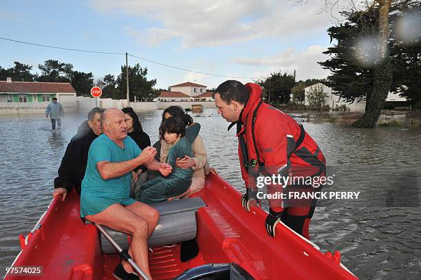 Residents are evacuated in a zodiac by firefighters, on February 28 as a result of heavy floods, in La Faute-sur-Mer western France. Dubbed...