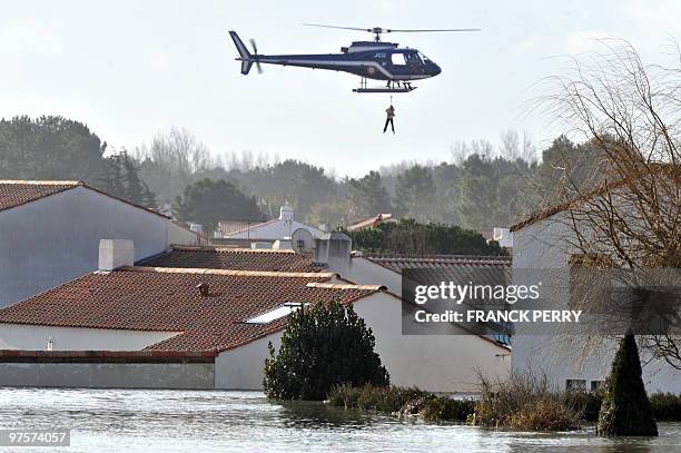 Person is airlifted by an helicopter of the National Gendarmerie, on February 28 as a result of heavy floods over a residential area, in La...