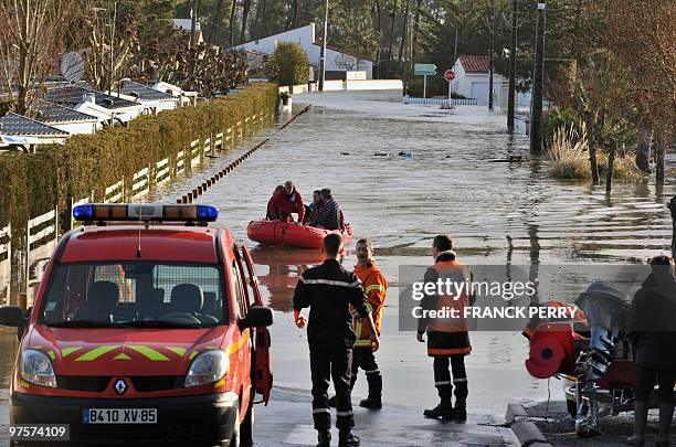 Residents are evacuated in a zodiac by firefighters, on February 28 as a result of heavy floods, in La Faute-sur-Mer western France. Dubbed...