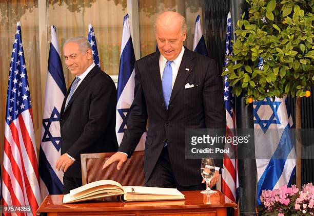 Israeli Prime Minister Benjamin Netanyahu walks past US Vice President Joe Biden as he prepares to sign the guestbook at the Prime Minister's...