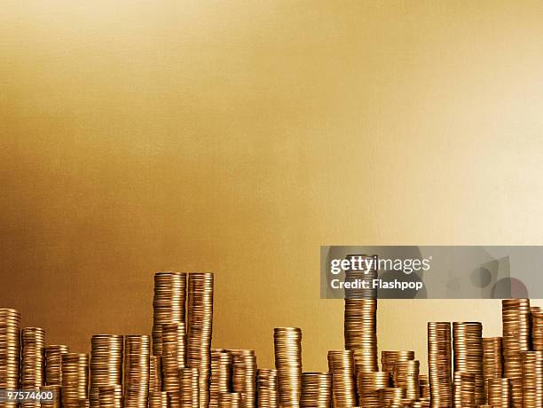 city scape made up of gold coins - gold coin stock-fotos und bilder