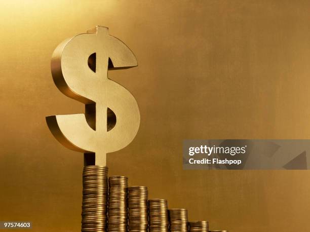 dollar sign balancing on gold coins - exploitation stock pictures, royalty-free photos & images