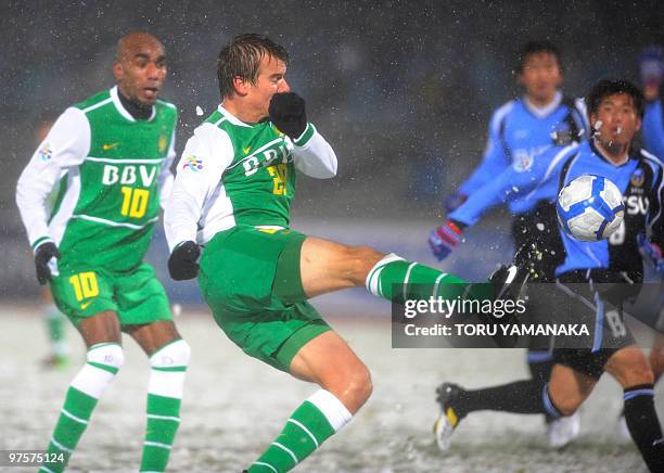 China's Beijing Guoan forward Griffiths Joel shoots the ball beside his teammate Saraiva Erivaldo Antonio against Japanese club Kawasaki Frontale...