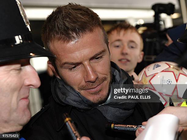 Milan's English midfielder David Beckham signs autographs as he arrives at Manchester Airport in Manchester, north-west England, on March 9, 2010...