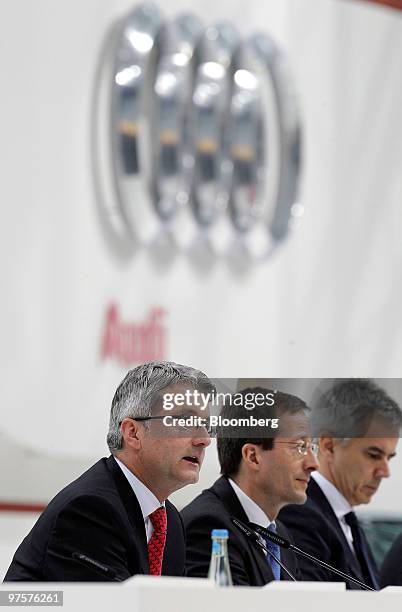 Rupert Stadler, chief executive officer of Audi AG, left, sits with Axel Strotbek, chief financial officer of Audi AG, center, during the company's...