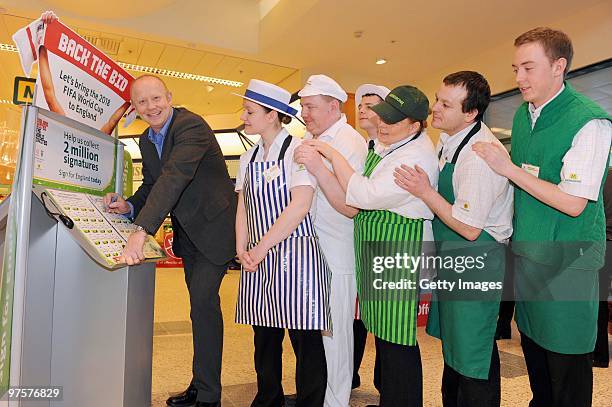 Former England footballer Mark Wright and Morrisons staff members pose during a photo call to promote Morrisons as a sponsor of the England bid to...