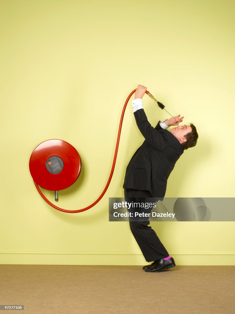 Obsessive business man cleaning fire hose