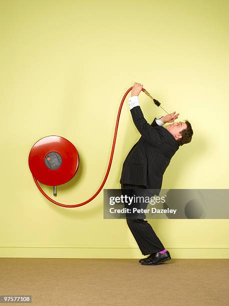 obsessive business man cleaning fire hose - fire hose stock pictures, royalty-free photos & images