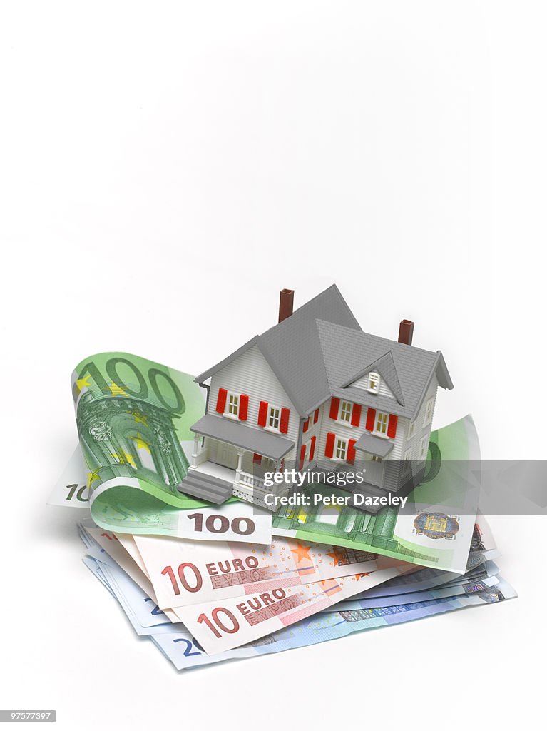 House balanced on pile of Euro bank notes