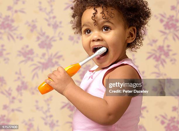 hispanic toddler cleaning teeth with toothbrush - elektrische zahnbürste stock-fotos und bilder