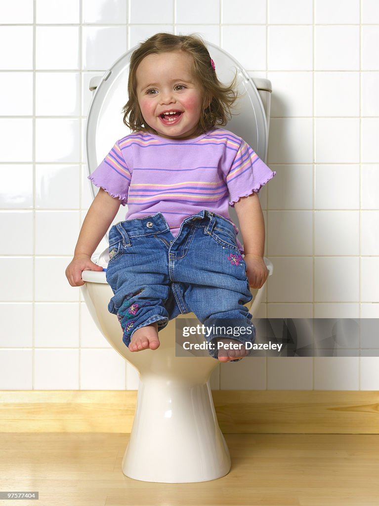 Toddler sitting on toilet training seat