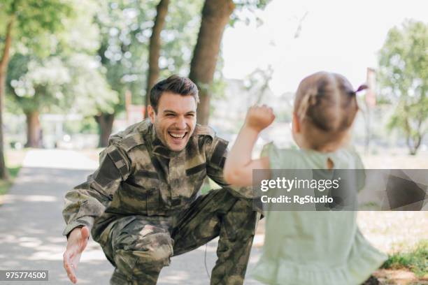 petite fille en courant vers le soldat - homecoming photos et images de collection