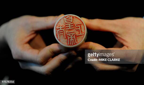 An expert holds a white jade seal of the 'Taishang huangdi' series estimated to fetch 6.4 million US dollars at auction, during a press preview of...