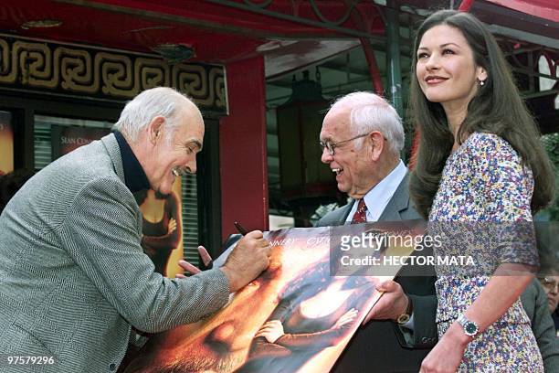 Actor Sean Connery with co-star Catherine Zeta Jones , signs a poster of the latest 20th Century Fox release "Entrapment" for Hollywood Honorary...