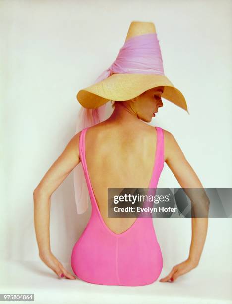Back view of model wearing pink maillot by Catalina and straw hat with pink chiffon scarf.
